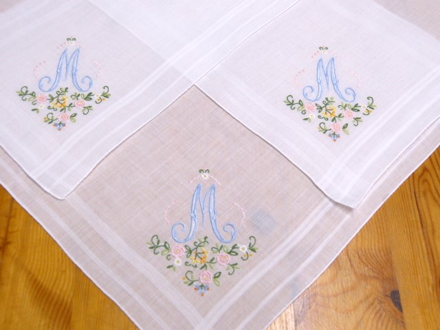 Drei weiße Batisttaschentücher mit einem großen Monogramm M und Blumen in einer Ecke hand roliert Größe: 34x34