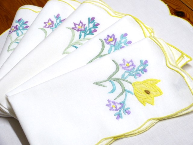 6 weiße Baumwollservietten mit Blumendekor in einer Ecke bunt frisch gebogter gelber Rand