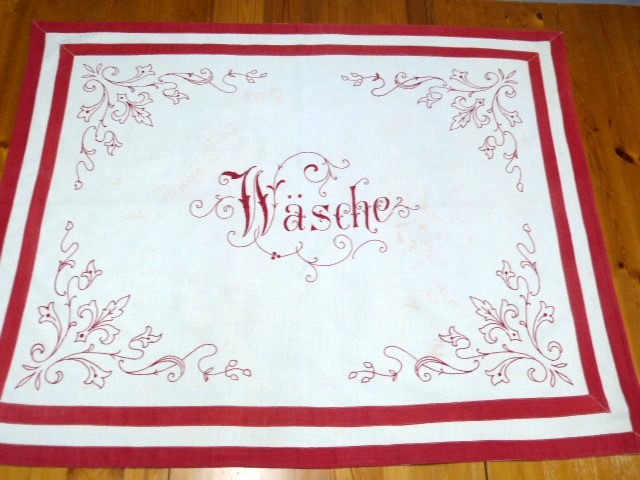 Wäschekorbabdeckung rot bestickt mittig Schnörkelschrift Wäsche Einfassung 2 rote Bänder 74x90 cm